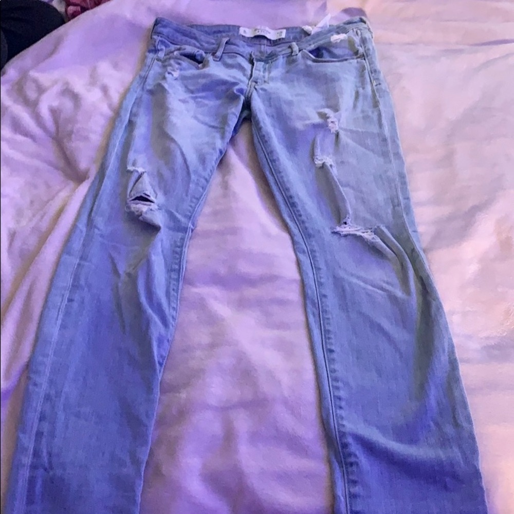 Light wash colored jeans with rips in them